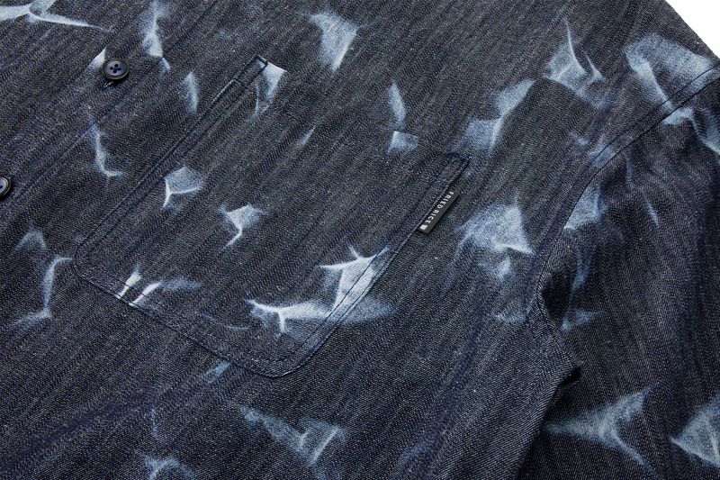 Close-up of a dark denim shirt with side pocket
