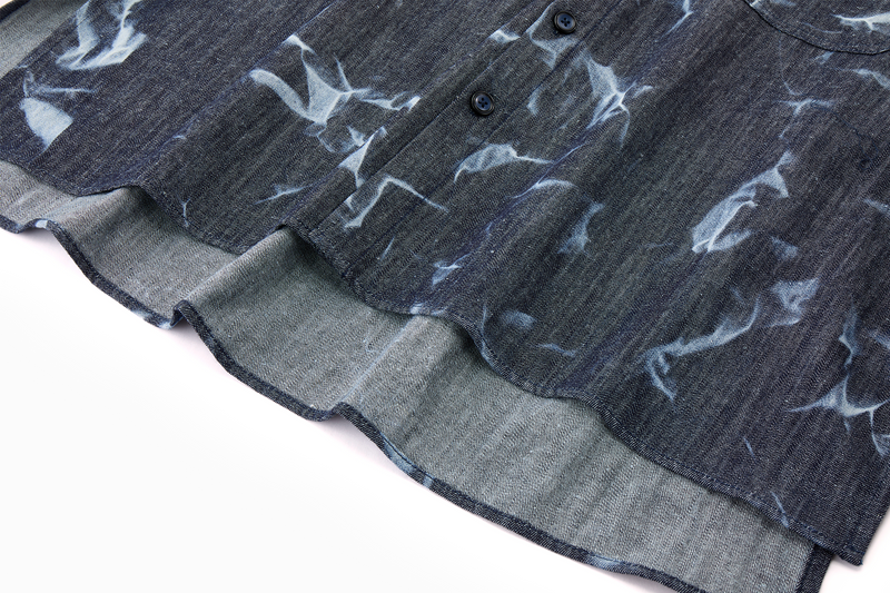 Close-up of a dark denim blue shirt with white abstract patterns hem