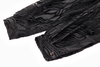 Black textured fabric with pleated cuff design on a white background