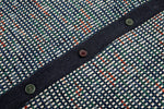 Close-up of a textured fabric with buttons and a checkered pattern