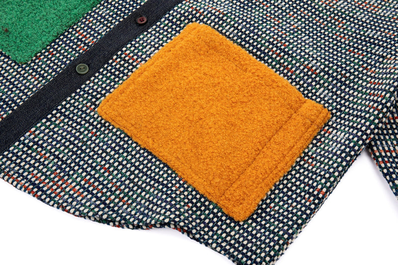 Textured fabric with a mustard yellow square patch on a multicolored background
