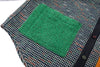 Textured green square patch on a patterned fabric background