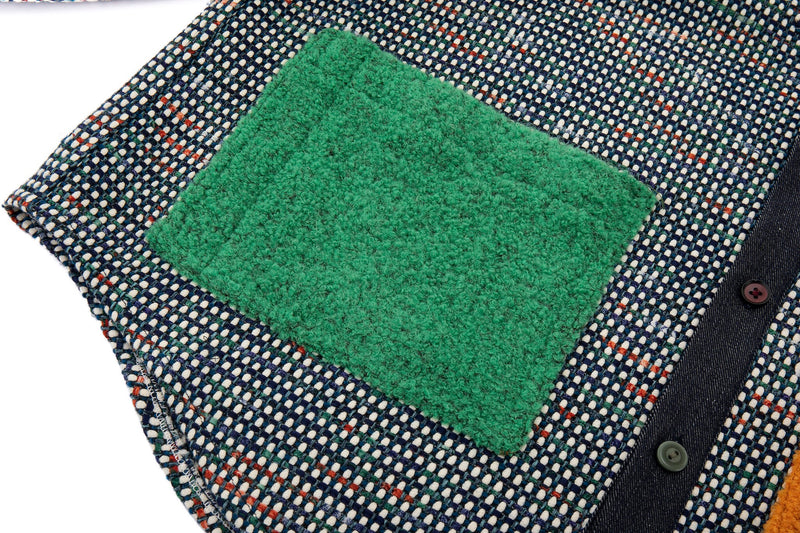 Textured green square patch on a patterned fabric background