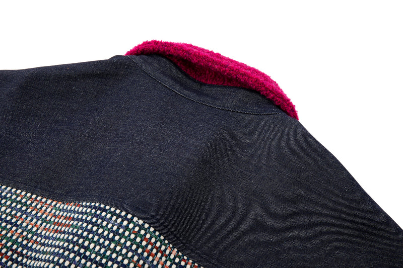 Close-up of a dark fabric surface with a textured pattern and a magenta collar.