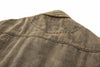 Close-up of a brown denim jacket subtle camo-inspired texture throughout